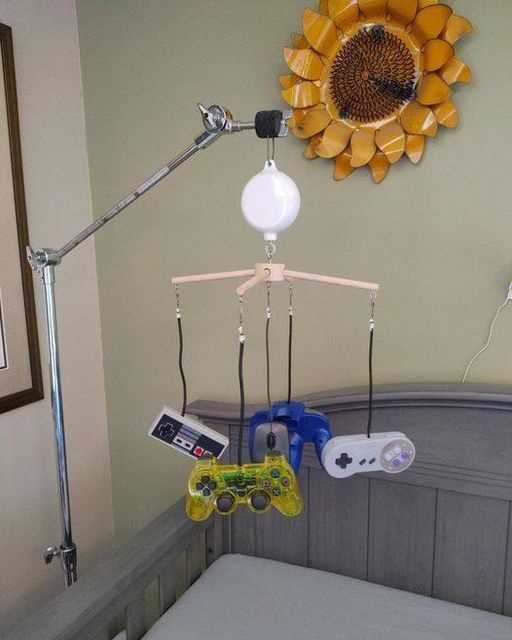 a baby toy hangs over a crib that has video game controllers